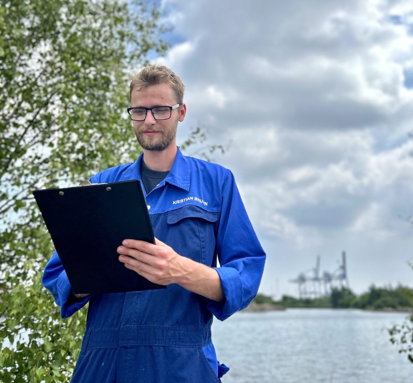 Technician with a clipboard by the harbour